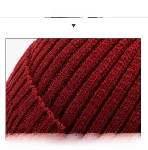 Macro detail of thick red knit texture and ribbed pattern on warm winter beanie hat