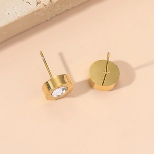 Macro shot of gold Roman numeral studs with central crystal and secure post backing