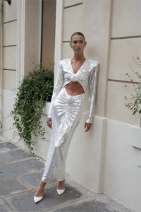 Detail of silver sequin dress showing deep V-neck, waist cutout, and 3D floral accents
