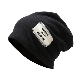 Thick black knitted beanie hat with retro streetwear patch on a clean white background