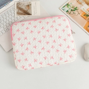 Close-up of quilted laptop sleeve with pink bow pattern and smooth zipper closure