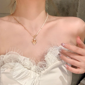 Collier élégant plaqué or avec pendentif feuille d'érable et perle sur un mannequin