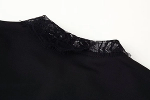 Close-up of elegant black lace neckline and knit fabric texture on the party dress