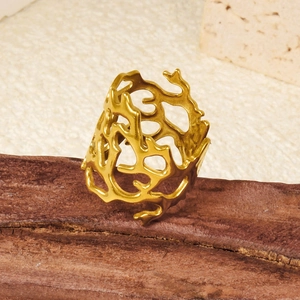 Irregular hollow cutout ring in matte gold finish on an artistic wooden display