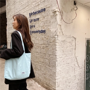 Bolso tote de lona azul claro con diseño espacioso y detalle de etiqueta tejida mini