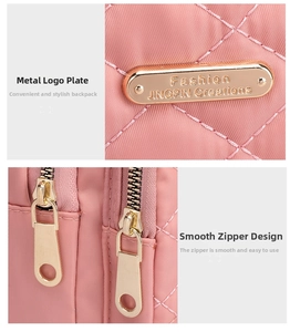 Detailed macro view of pink quilted nylon fabric with golden metal logo and smooth zippers