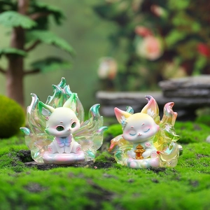 Luminous fox figurine detail featuring pearlescent tails on natural moss background
