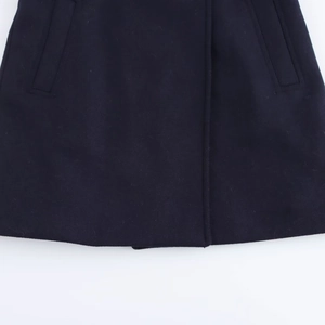 Detail of dark wool blend coat showing reinforced stitching and hidden side pockets