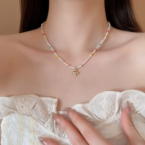 Detail of colorful mushroom pendant necklace with mixed beads on model neck