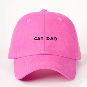 Close-up of pink baseball cap with black CAT DAD embroidery and breathable cotton texture