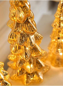 Close-up of golden mercury glass Christmas tree ornament with warm glowing lighting