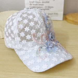 Detailed embroidery view of lace baseball cap with 3D floral accents and pearls