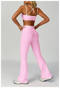 Vista posteriore del set yoga rosa con reggiseno incrociato e pantaloni a zampa