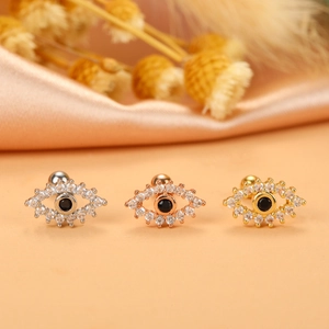 Macro shot of evil eye cartilage earrings in silver, rose gold, and gold plating