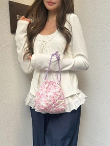 Detail of pink floral quilted cotton drawstring pouch held by model in casual scene
