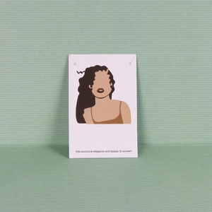 Detail view of black round stud earrings displayed on an illustrated white card
