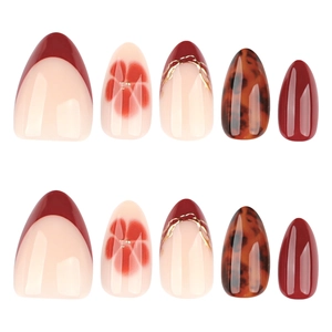 Almond-shaped press-on nails featuring red French tips, amber textures, and floral designs
