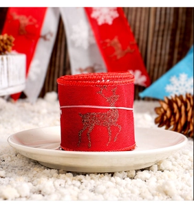 Rollo de cinta navideña roja con estampado de renos brillantes en un plato blanco