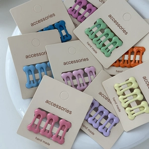 Close-up of colorful candy-colored bone shaped mini hair clips in various bright hues