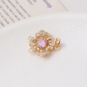 Macro shot of 14K gold plated flower clasp with pink gemstone and zircon for DIY jewelry