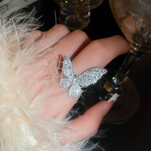 Macro shot of a large silver butterfly ring with sparkling zircon wings on finger