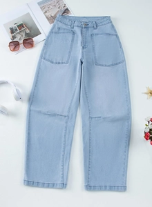 Flat lay of light blue cargo jeans with large pockets and stylish summer accessories