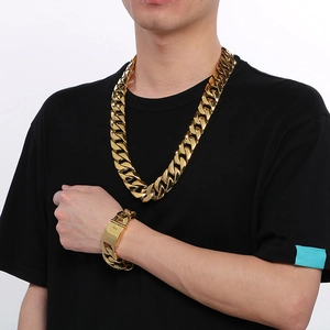 Polished gold 24mm Cuban link necklace and bracelet set displayed on a male model