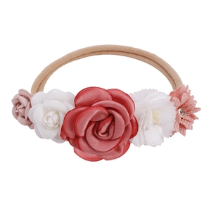 Detailed close-up of handmade fabric floral baby headband with red roses and pink petals