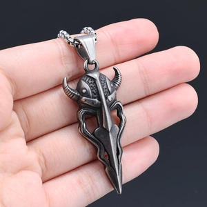 Detail of vintage steel warrior mask pendant with horn helmet and tribal totem on chain