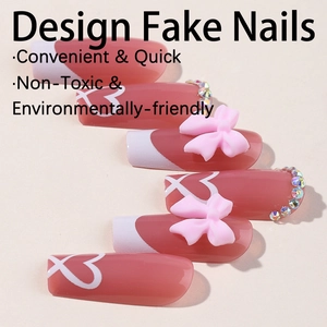 Pink press-on nails with white heart patterns, 3D bows and rhinestones on beige background