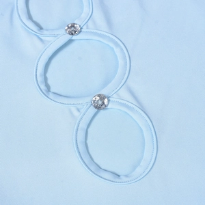 Macro shot of light blue knit dress detail with cutout design and rhinestone buckle