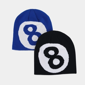 Close-up of black and blue knit beanies featuring classic jacquard 8-ball pattern