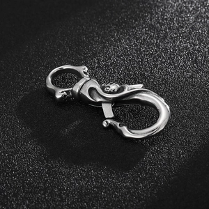 Close-up of a silver stainless steel S-shaped lobster clasp with polished metal texture