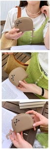 Detail of beige cat-shaped card holder with PU leather texture and cat face embroidery