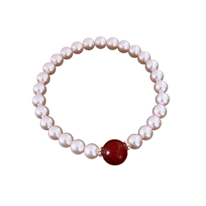 Bracelet de perles roses avec agate rouge et accents métalliques sur fond blanc