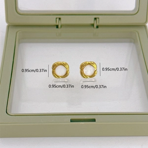 Macro detail of gold vintage pearl stud earrings with size measurements in a green case