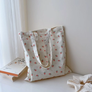 Close-up of floral cotton tote bag with red flower patterns and minimalist cloth label