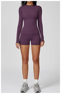 Détail du haut à manches longues et col rond violet foncé extensible avec short de fitness