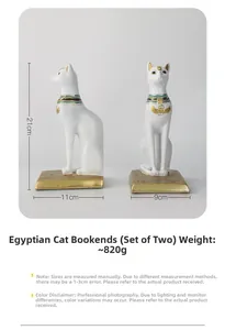 Detail of white Egyptian cat bookends with gold hieroglyphs and blue collar accents