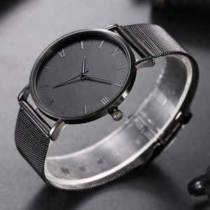 Macro shot of minimalist black quartz watch with mesh strap and Roman numeral markers