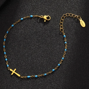 Gold stainless steel bracelet with blue beads and a cross pendant on a black background