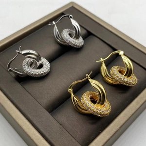Elegant gold and silver double hoop earrings with pavé cubic zirconia on brown velvet