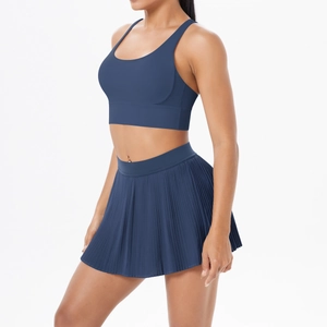 Détail d'une jupe plissée taille haute et d'un soutien-gorge de sport bleu marine en tissu respirant