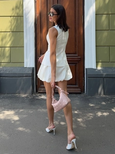 Détail de la mini-robe blanche sans manches à texture lin et sac à main tissé rose