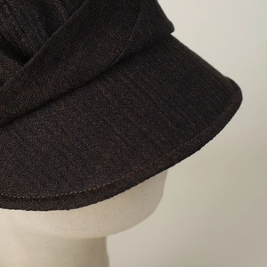 Dark brown linen newsboy cap with vintage texture and detailed stitching on brim