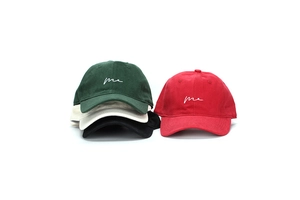 Detail of four baseball caps in green, red, white, and black with me embroidery