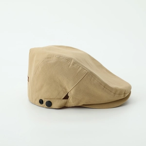 Detail view of khaki cotton flat cap showing adjustable side buckle and stitching