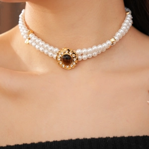 Primo piano della collana di perle occhio di tigre a due strati con ciondolo d'oro