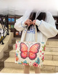 Detail of the butterfly floral canvas tote bag with woven handles shown in a lifestyle setting