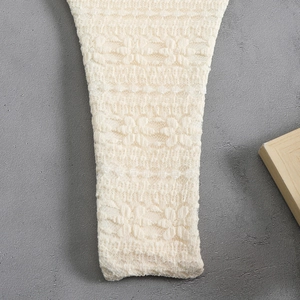 Close-up of beige lace cover-up featuring intricate hollow-out floral patterns